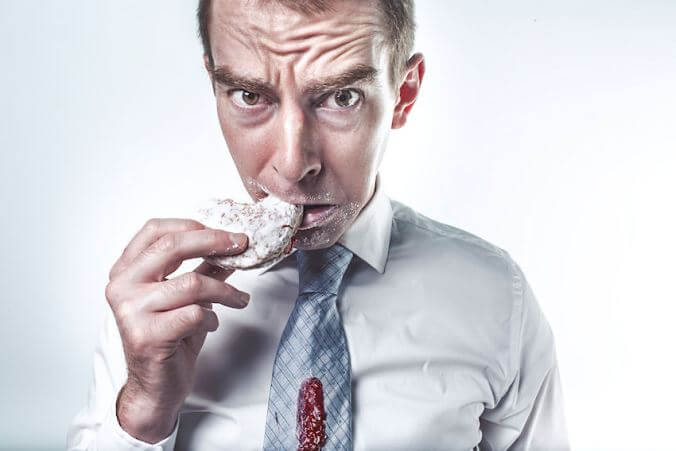 man dribbling a jelly donut on his shirt