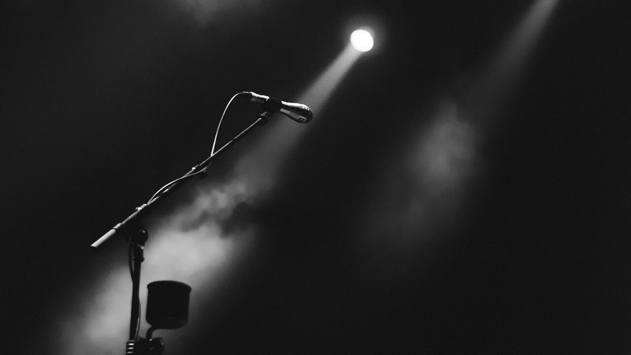 microphone and spotlight on an empty stage | purpose of marketing in unprecedented times