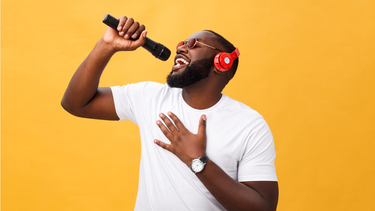 young man singing energetically into a microphone | use your brand voice in your B2B marketing content