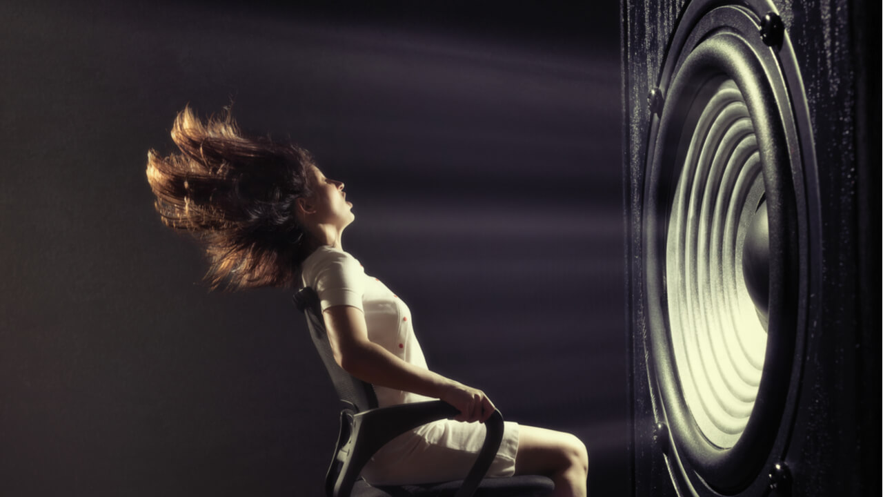 woman sitting in front of a giant subwoofer that’s blasting her back in her chair | boost your B2B blog performance