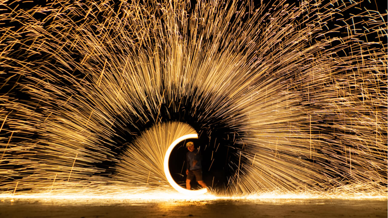 time lapse photo of a performer spinning sparks against a dark background | company website marketing strategy