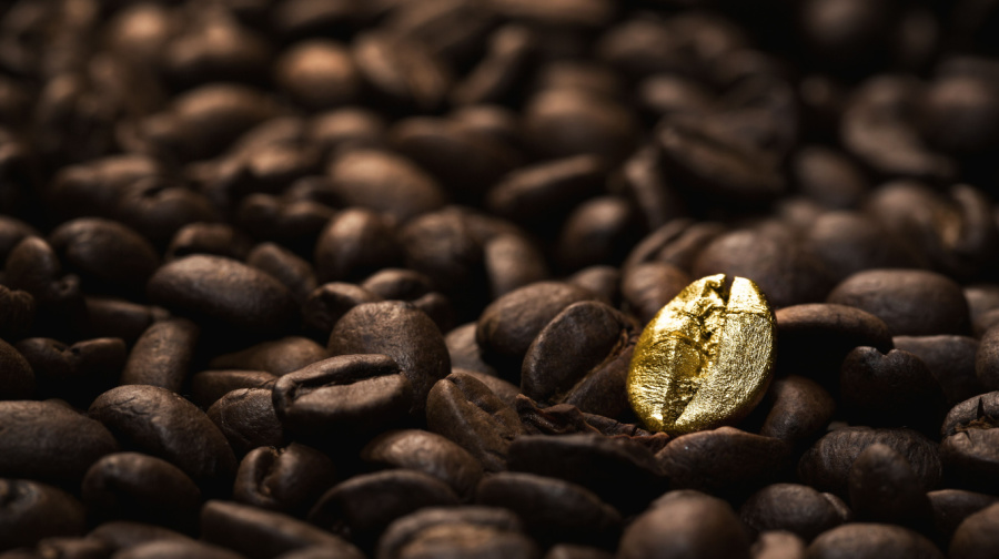 one gold coffee bean among a pile of brown coffee beans | core marketing message brand differentiator