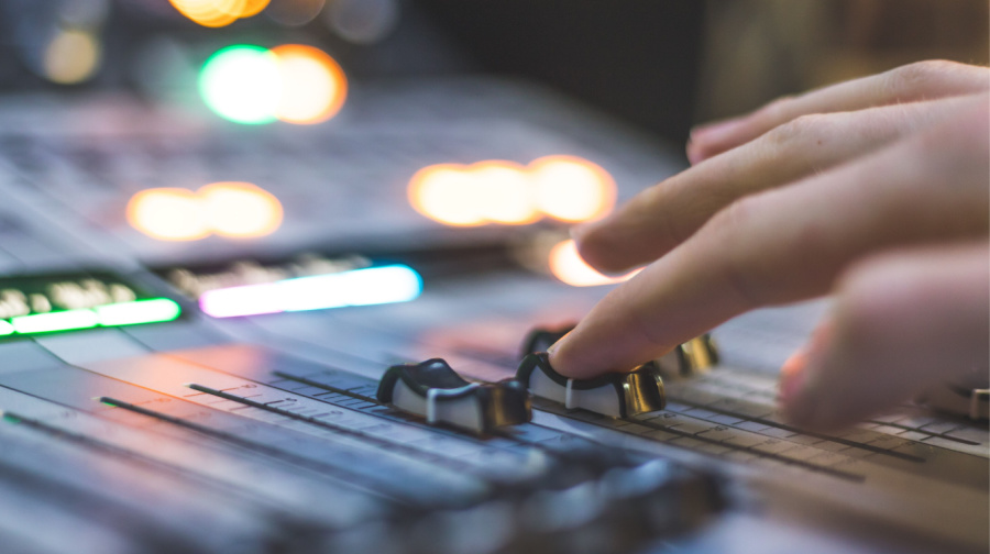 closeup of sound engineer’s hands on a soundboard | cybersecurity website performance