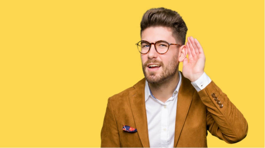 young man with cupped hand to his ear _ buyer personas motivate ideal clients to convert